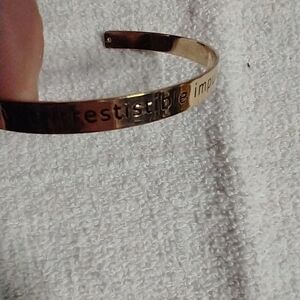 Goldtone cuff bracelet says wanderlust:  irresistible impulse to travel